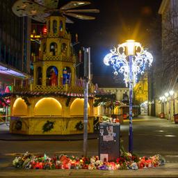 An der Zufahrt zum Weihnachtsmarkt in Magdeburg stehen Kerzen und Blumen.