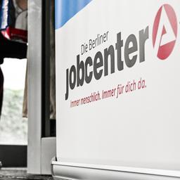 Menschen stehen am Eingang eines Jobcenters