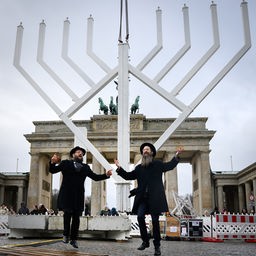 Rabbiner Yehuda Teichtal (l) und Rabbi Shmuel Segal tanzen bei der Einweihung Chanukka-Leuchters auf dem Pariser Platz in Berlin.