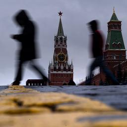 Menschen gehen in Moskau (Russland) vor dem Erlöserturm über den Roten Platz.