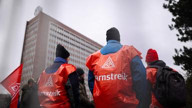 IG-Metall-Mitglieder stehen am Stammsitz von Volkswagen in Wolfsburg.