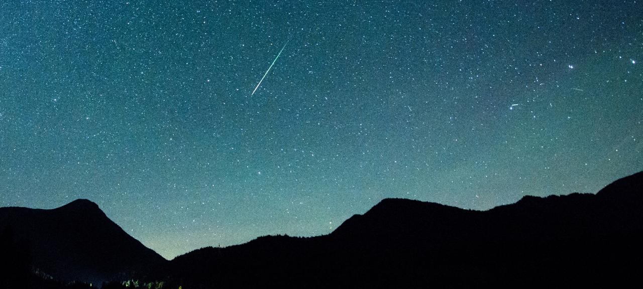 Eine Sternschnuppe leuchtet am Himmel über dem bayrischen Walchensee. (Archivbild vom 12.08.2018)