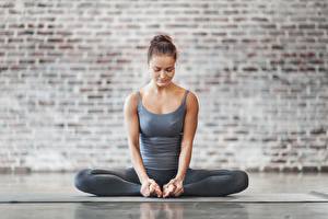 Fotos Sitzt Joga Posiert Hand Bein Baddha konasana Mädchens