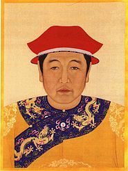 A painted image of the head and chest of a black-haired man with droopy eyes wearing a white-edged two-tiered red cap and a bright yellow garment whose lapels are decorated with five-clawed yellow dragons against a blue background with clouds and vegetation.