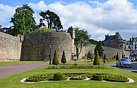 Photographie d'un mur d'enceinte devant un parterre fleurie.