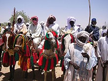 Photos d'une dizaine de personnes debout ou à cheval habillées en tenue traditionnelle