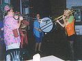 Two trombone players on either side of a bass drummer