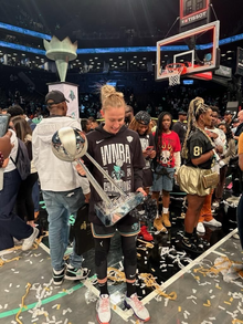 Courtney Vandersloot holds the New York Liberty's 2024 WNBA Championship Trophy during a at a post-win celebration at the Barclay's Center.