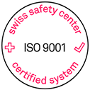 Circular logo with a black outline and red text reading "swiss safety center certified system" around the edge. In the center, it says "ISO 9001". A red cross is on the left, and a red checkmark is on the right.