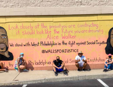 Teenagers sitting in front of a mural with George Floyd and Breanna Taylor in support of Black Lives Matter