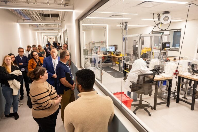 people watch a robotic arm at bioMérieux