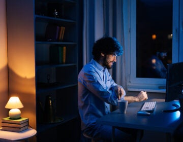 A young man is seen in his home, awake and alert at late hours. (Bigstock/dikushin)