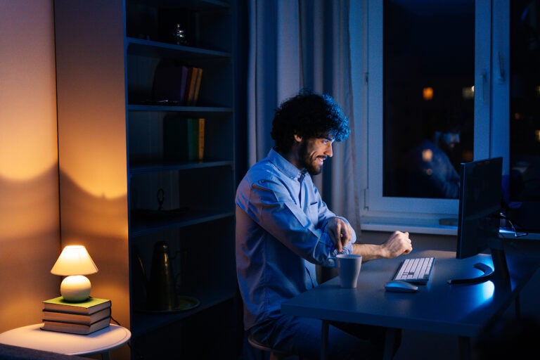 A young man is seen in his home, awake and alert at late hours. (Bigstock/dikushin)