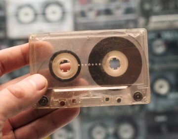 A person holds one old cassette tape out of many. (Bigstock/Tik.Tak)