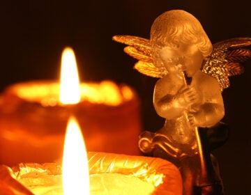 transparent decoration angel making music upon Advent wreath