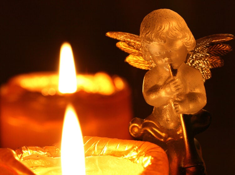 transparent decoration angel making music upon Advent wreath