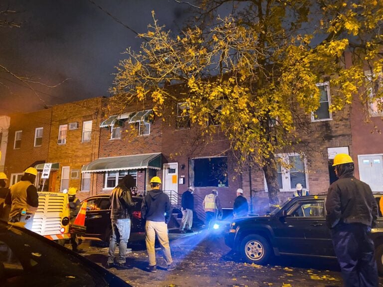 Crews stand at the scene of a gas explosion at a South Philly home