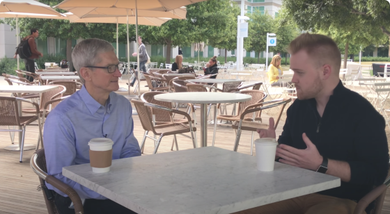 two men talking while sitting at square table in large outdoor patio