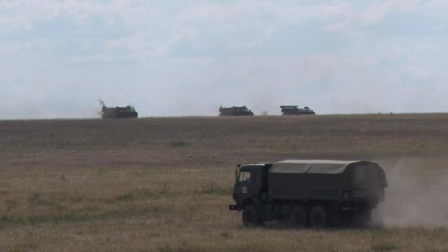 tanks and armored personnel carriers moving around the range at military exercises