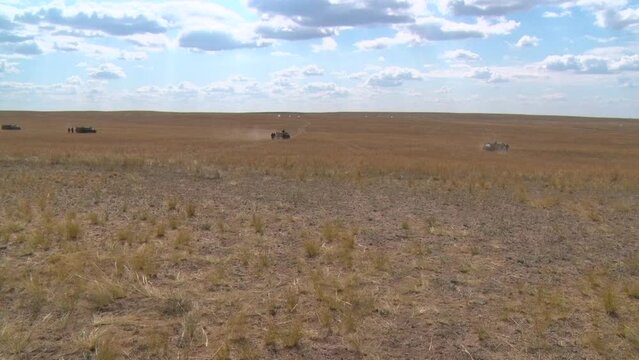 tanks and armored personnel carriers moving around the range at military exercises