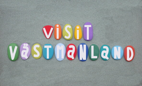 Visit Vastmanland, a county or ln in central Sweden, souvenir composed with multi colored hand painted stone letters over green sand