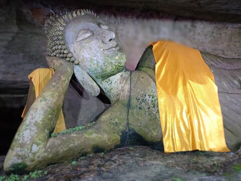 statue of buddha ana inside the cave old stone rock texture in cave south Thailand 