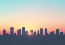 Widescreen 1080p Wallpaper with silhouette of a modern city skyline at sunset, soft gradient sky.