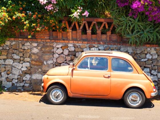 Gelber Fiat (Auto) vor einer Mauer in Italien