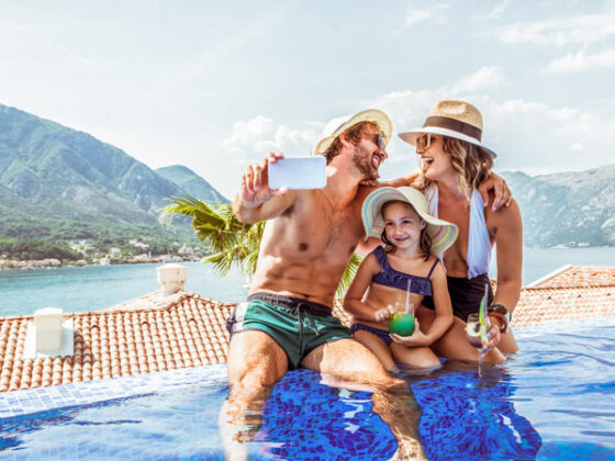 Familie genießt gemeinsame Zeit im Infinity-Pool mit malerischem Blick auf die Berge von Montenegro im Hintergrund