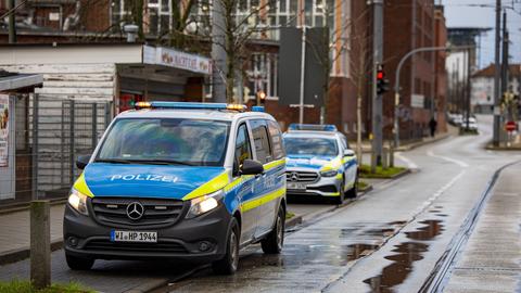 Zwei Polizeiwagen stehen am Rand einer Straße nahe des Ortes, wo der Verletzte gefunden wurde.