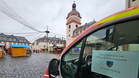 Ein Fahrzeug der Feuerwehr steht auf einem Zugangsweg zum Weihnachtsmarkt in Weilburg. In der Fensterscheibe eine Notiz: Dieses Fahrzeug ist hier für ihre Sicherheit abgestellt. Ihre Stadt Weilburg