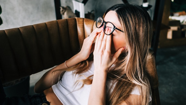 Eine junge Frau liegt erschöpft auf der Couch. Sich erholen ist wichtig. Es gibt außerdem zahlreiche Tipps, um wieder mehr Energie zu bekommen. Allerdings muss man aufpassen, dass zu viel Stress und eine zu hohe Belastung nicht in einen Burnout oder eine Depression münden. | Bild: colourbox.com