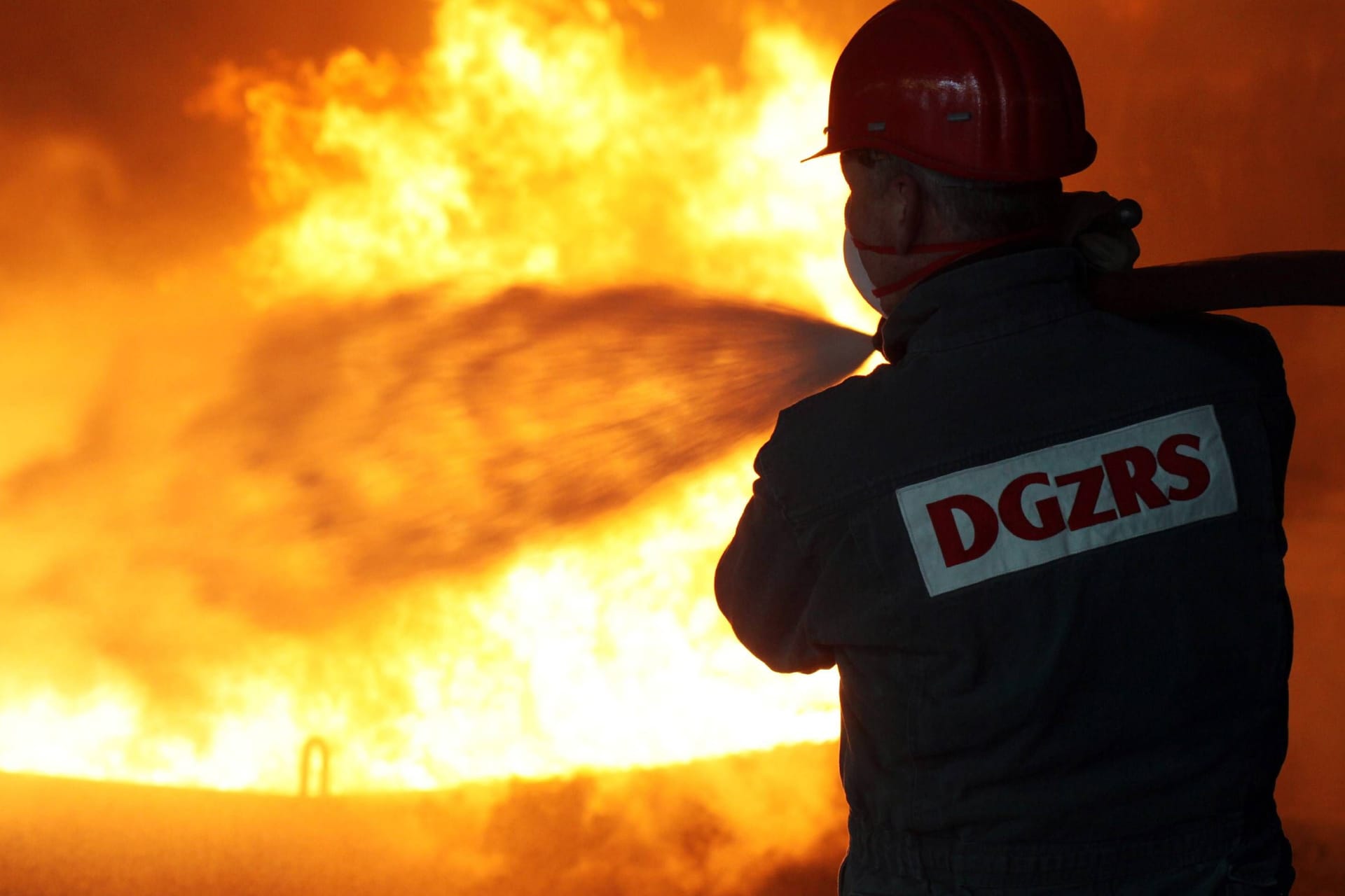 Feuerwehrmann löscht Brand (Symbolbild): In Boltenhagen ist eine Villa durch ein Feuer zerstört worden.