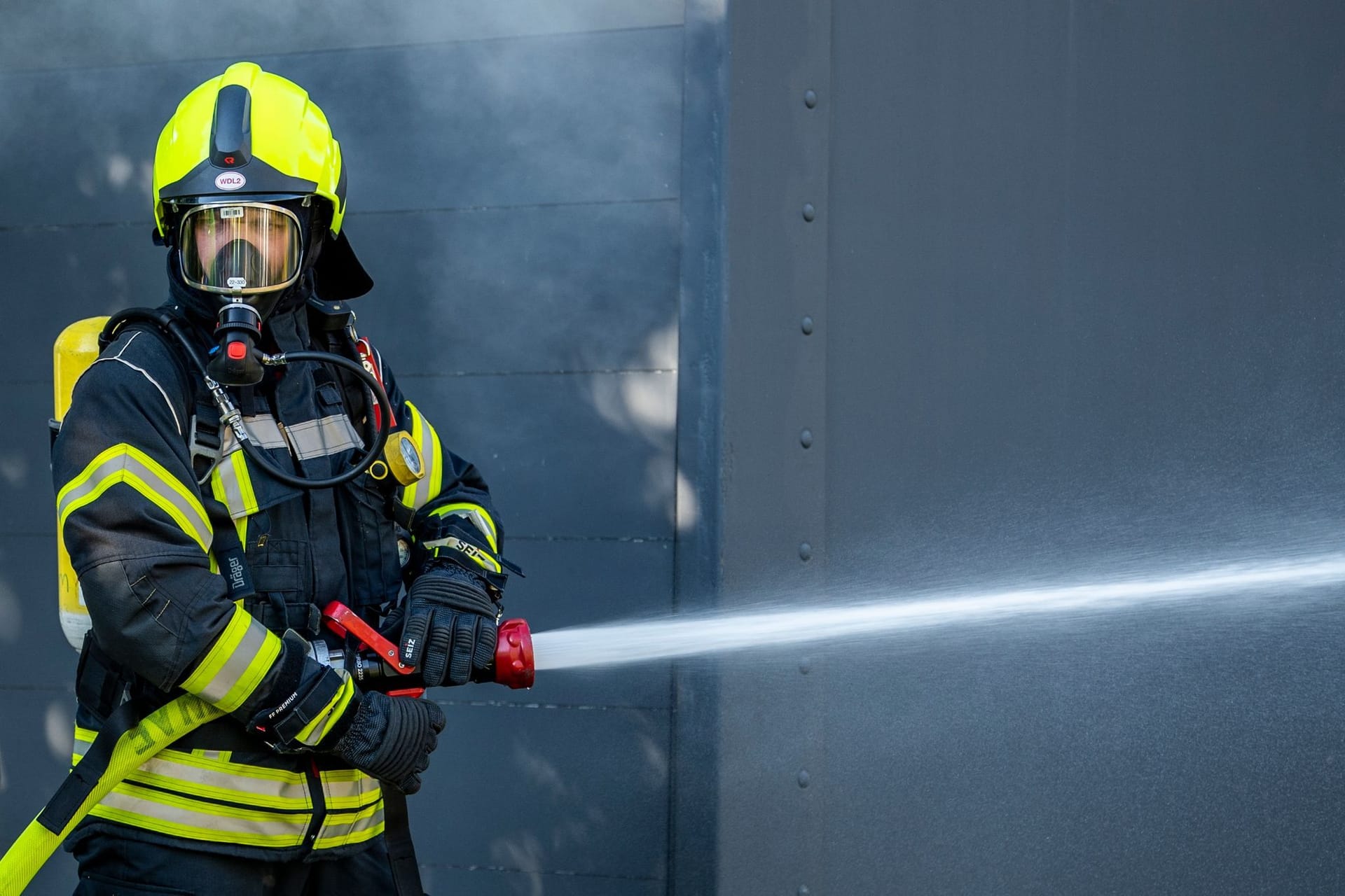 Ein Mitglied der Feuerwehr bei einem Löscheinsatz (Symbolbild): In Brandenburg hat ein Haus gebrannt.