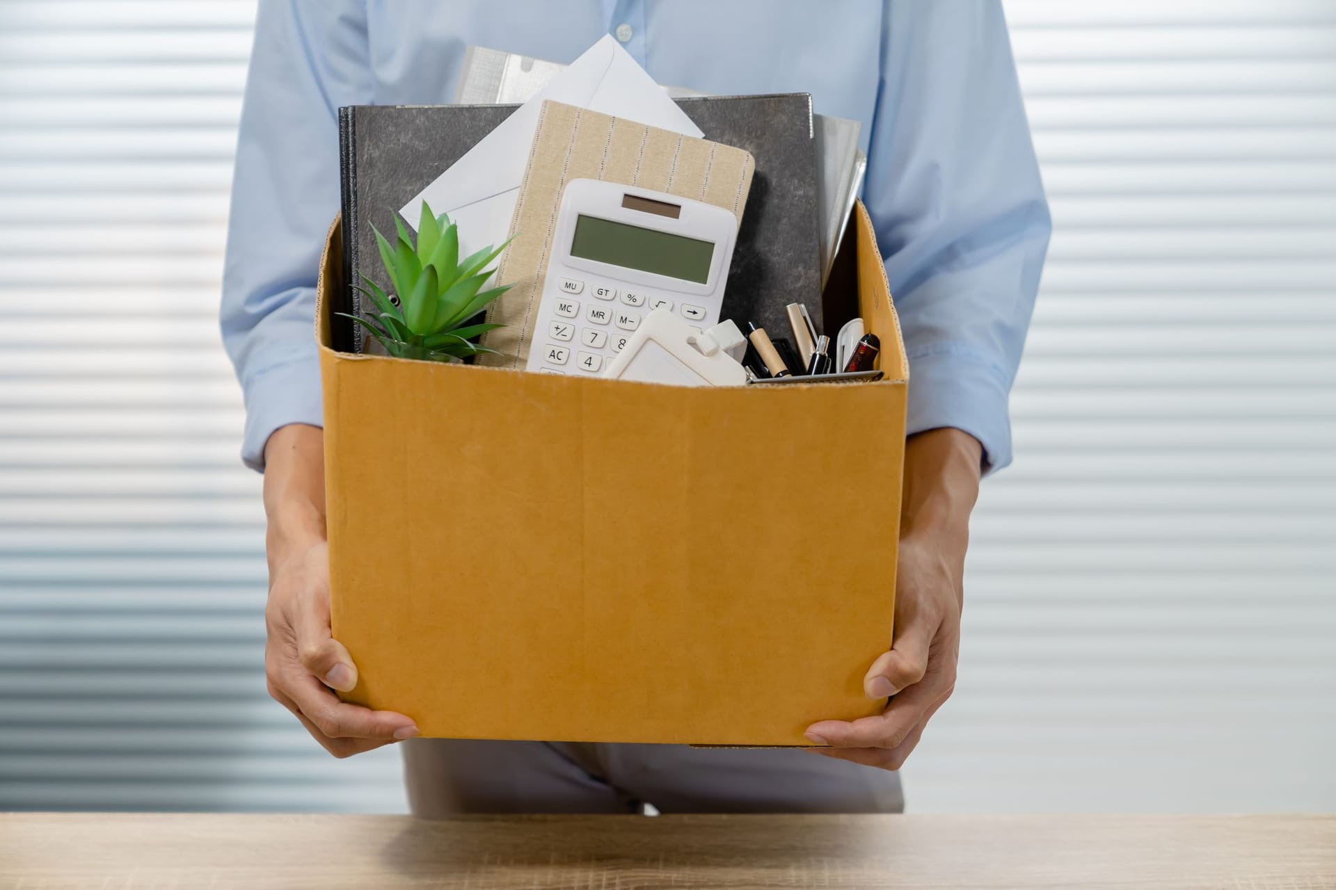 Angestellter packt seine Sachen und verlässt das Büro