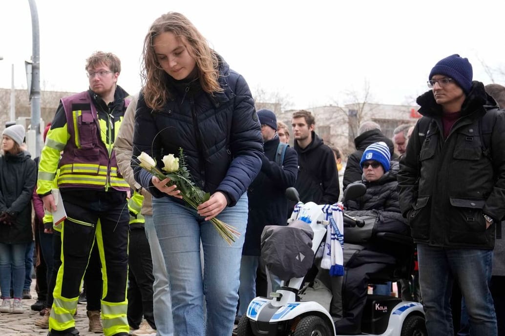 Trauernde legen vor der Johanniskirche Blumen ab: Die Menschen in Magdeburg sind nach dem Anschlag auf den Weihnachtsmarkt geschockt.