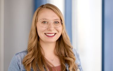 Eine Frau steht vor einem Fenster. Es ist Vivien Engel aus dem Sekretariat des Bauamtes.