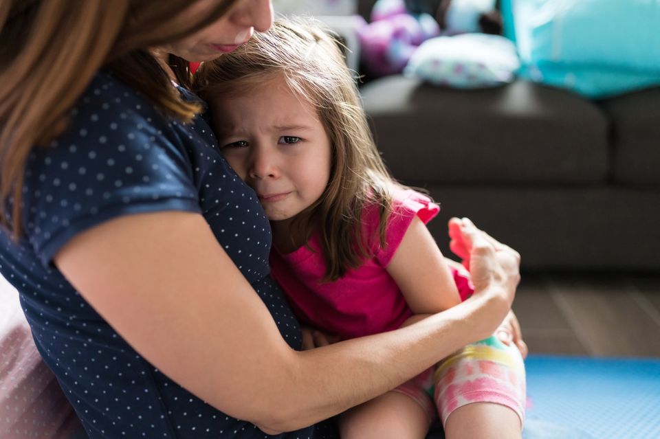 Mutter tröstet kleine Tochter