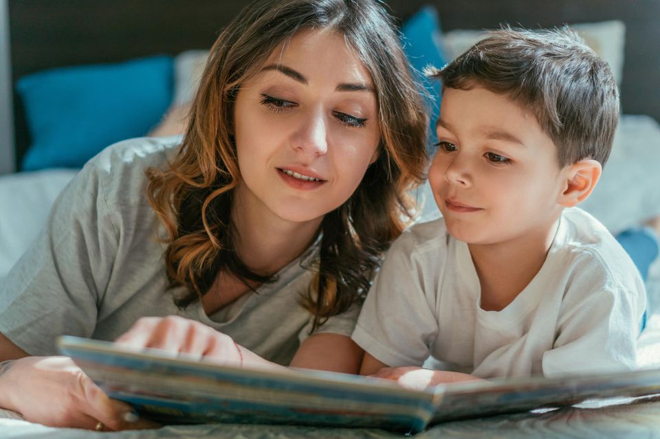 Wimmelbücher: Mutter und Sohn schauen sich ein Wimmelbuch an.