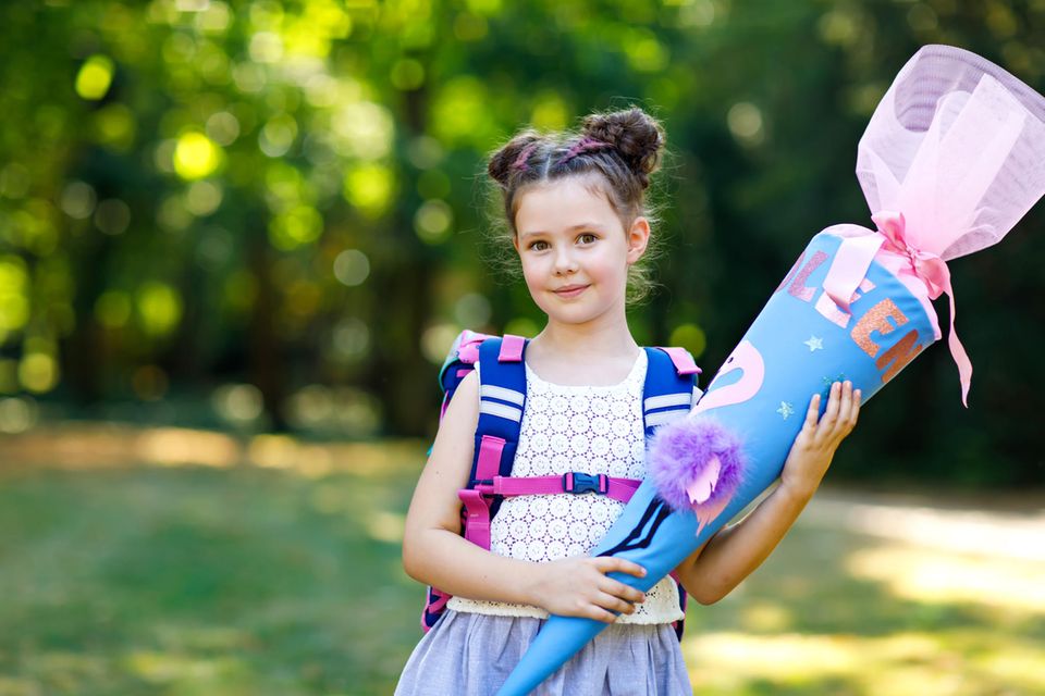 Mädchen hält ihre Zuckertüte auf der Einschulung