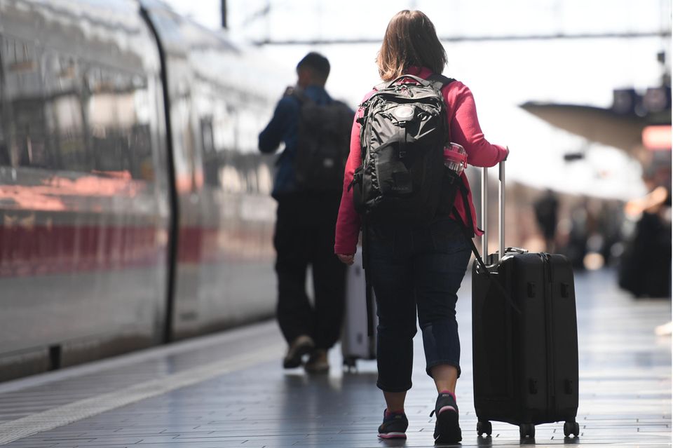 Frau mit Koffern am Bahnsteig