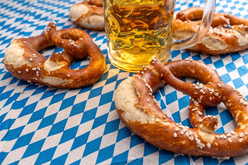 Salzbrezeln und Bier auf einer blauweißen Tischdecke