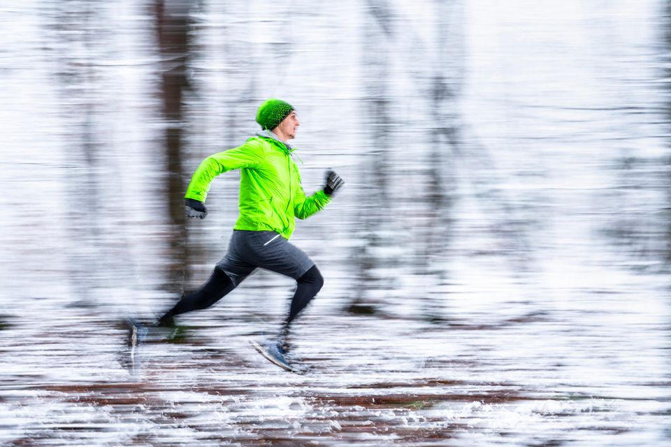 Joggen läuft durch einen verschneiten Wald.