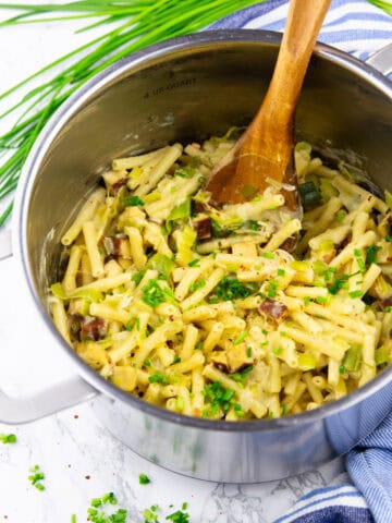 a pot with one pot pasta with leek and tofu on a marble countertop