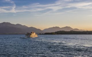 Een boot van de Chiemsee Schifffahrt op het meertje voor de bergen