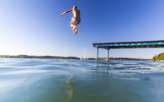 Jongen springt het water in