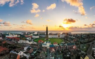 Zonsondergang bij de Nieuwe Vuurtoren in het centrum van Borkum, een eiland in Nedersaksen, Duitsland