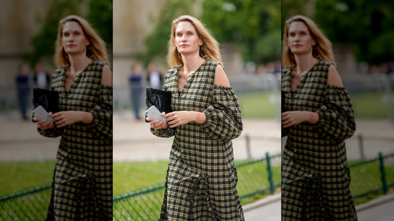 A woman wearing a plaid cold-shoulder maxi dress.