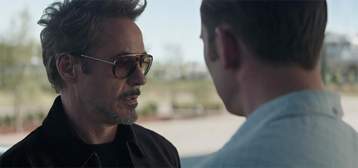 Tony Stark wears sunglasses and talking with a man