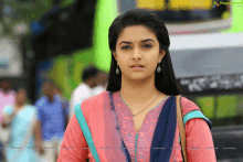 a woman in a pink and blue dress is standing in front of a sign that says ragalahari